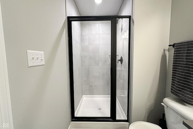 bathroom featuring a stall shower and toilet