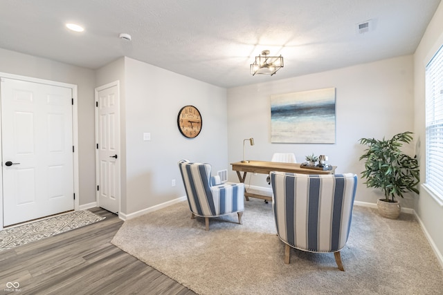 office area with a wealth of natural light, wood finished floors, visible vents, and baseboards