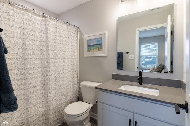 bathroom with toilet, visible vents, and vanity