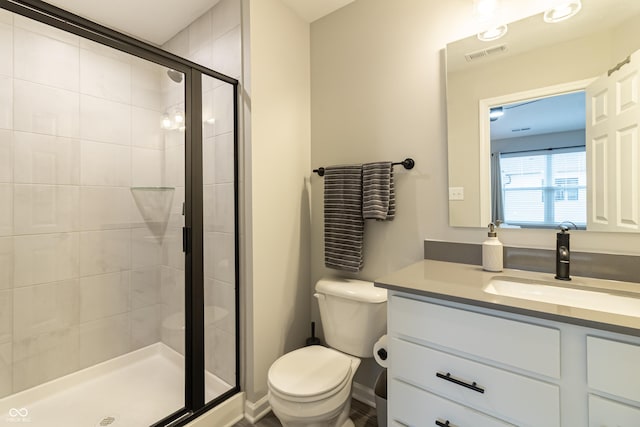 full bath with visible vents, vanity, a shower stall, and toilet