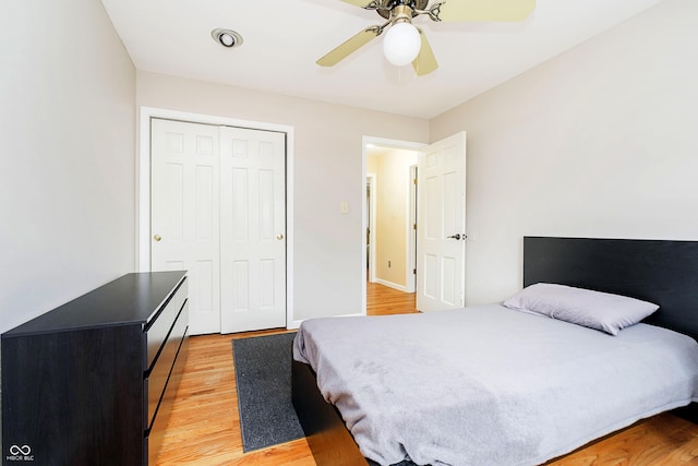 bedroom featuring a ceiling fan, a closet, and light wood-style flooring