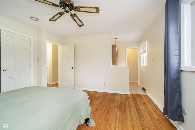 bedroom featuring a ceiling fan, light wood-style flooring, and baseboards