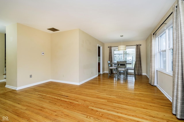 unfurnished dining area with baseboards and light wood-style floors