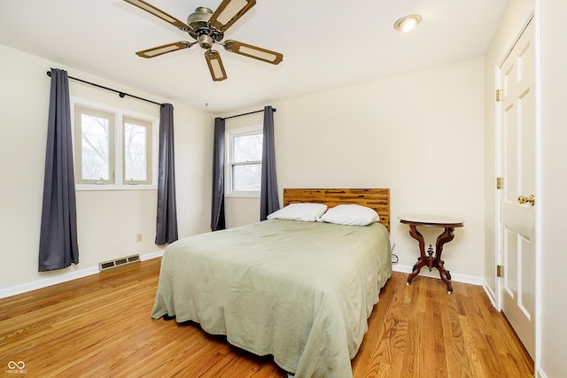 bedroom featuring wood finished floors, visible vents, and baseboards