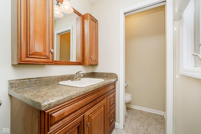 bathroom featuring baseboards, vanity, toilet, and tile patterned floors