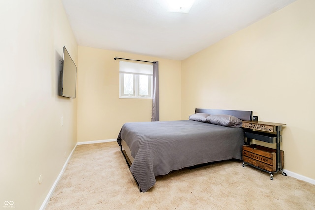 bedroom featuring baseboards and light colored carpet