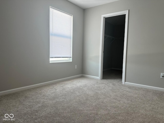 carpeted empty room featuring baseboards