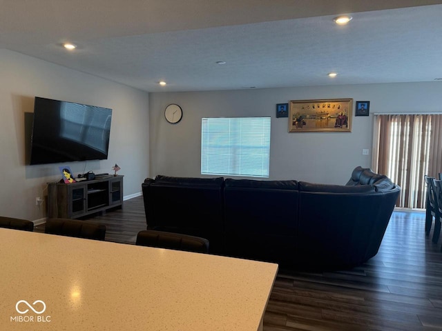 living area with recessed lighting, dark wood-type flooring, and baseboards