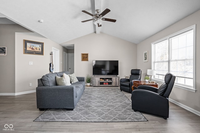 living area with ceiling fan, lofted ceiling with beams, baseboards, and wood finished floors