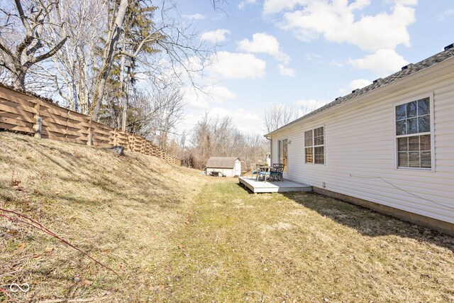 view of yard featuring a wooden deck, a shed, and an outdoor structure