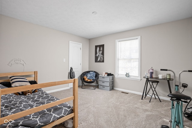 carpeted bedroom with a textured ceiling, visible vents, and baseboards