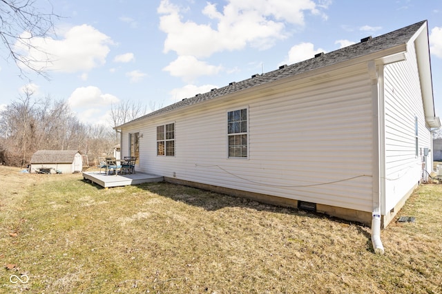 rear view of house with a storage unit, a lawn, crawl space, a deck, and an outdoor structure