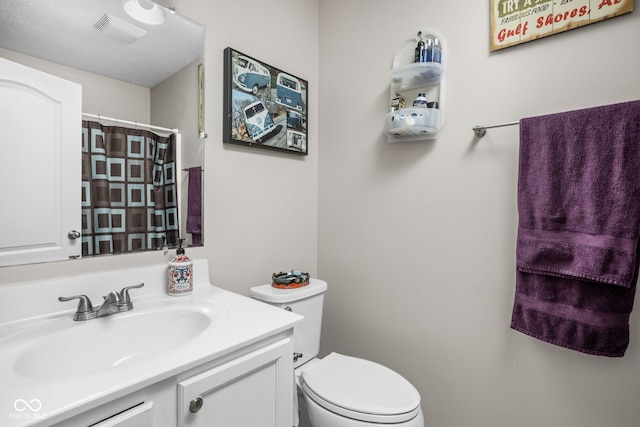 full bathroom featuring toilet, curtained shower, vanity, and visible vents