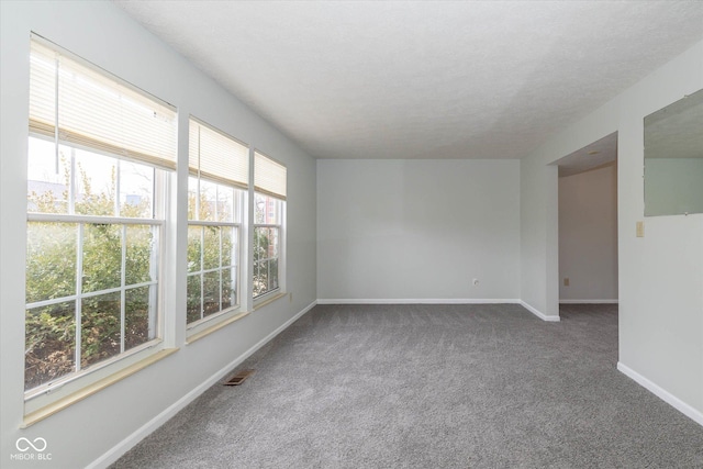 carpeted empty room with visible vents and baseboards