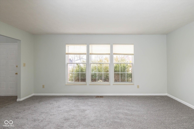 unfurnished room featuring baseboards, visible vents, and carpet flooring