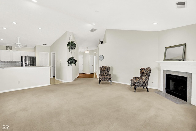 unfurnished room with a fireplace, visible vents, light carpet, vaulted ceiling, and baseboards