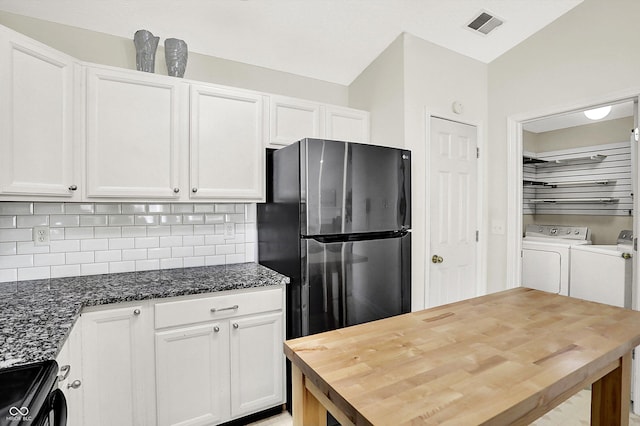 kitchen with visible vents, wooden counters, freestanding refrigerator, electric range oven, and washer and clothes dryer