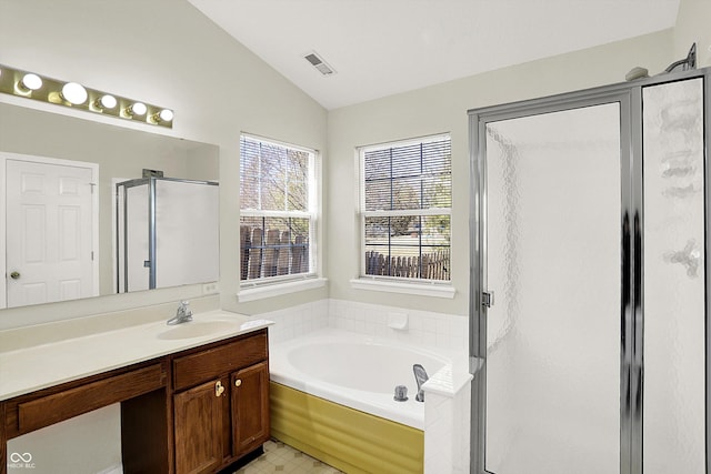 bathroom with visible vents, vanity, vaulted ceiling, a bath, and a stall shower