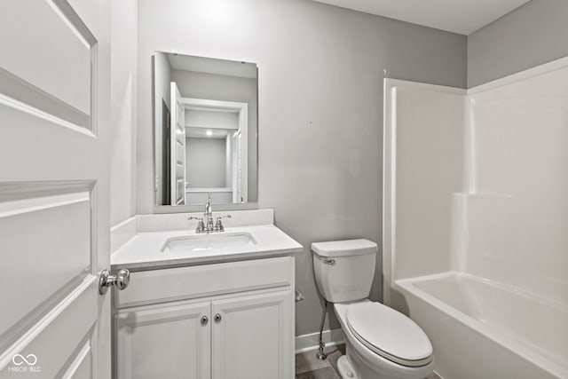 bathroom featuring toilet, washtub / shower combination, baseboards, and vanity