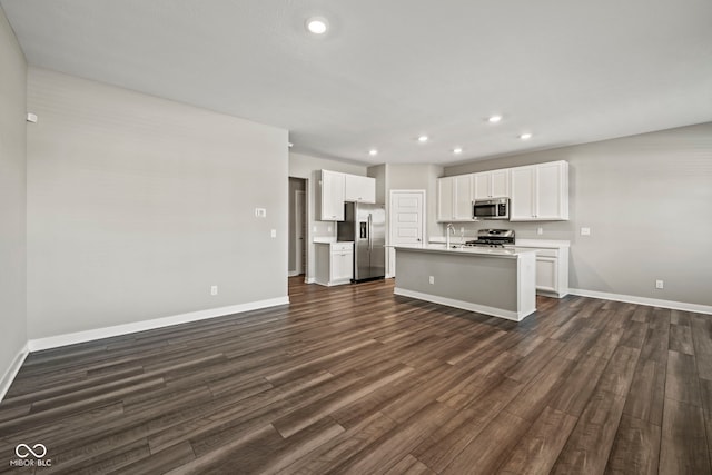 kitchen featuring light countertops, appliances with stainless steel finishes, dark wood-type flooring, and recessed lighting