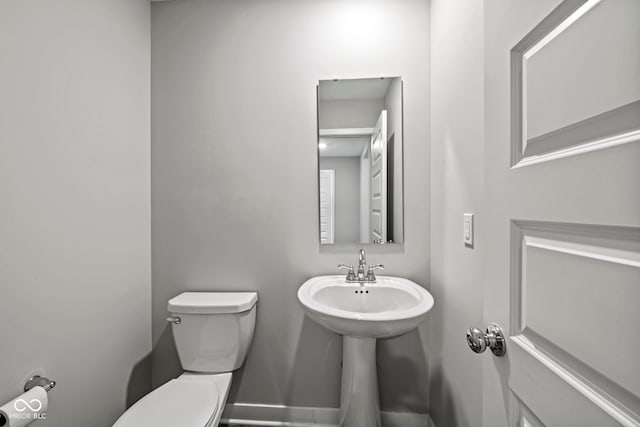 bathroom with baseboards and toilet