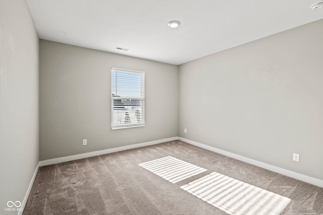 empty room with baseboards, visible vents, and carpet flooring