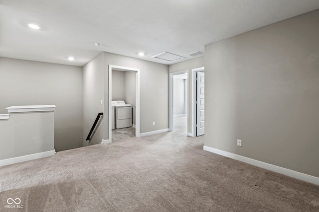 carpeted empty room with washer / dryer, attic access, baseboards, visible vents, and recessed lighting