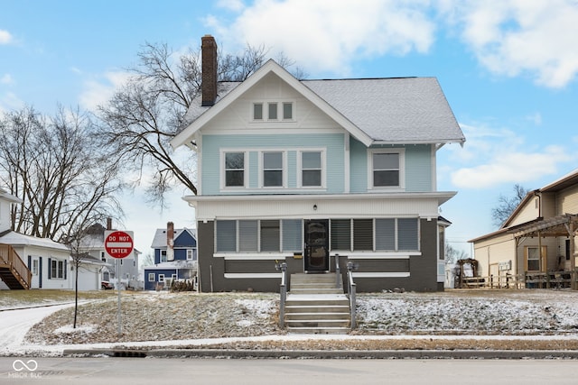 view of front of property featuring brick siding and a chimney