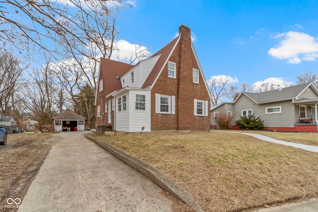 exterior space featuring brick siding, a chimney, and a front yard