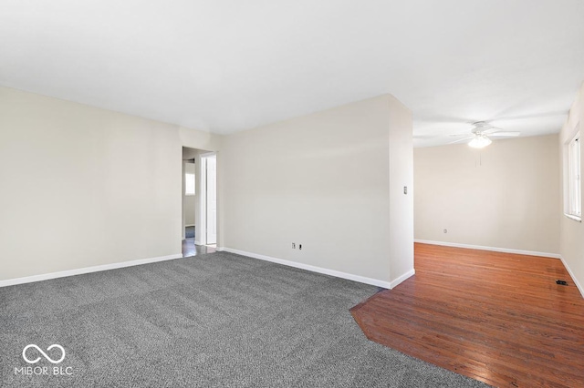 empty room with a ceiling fan and baseboards