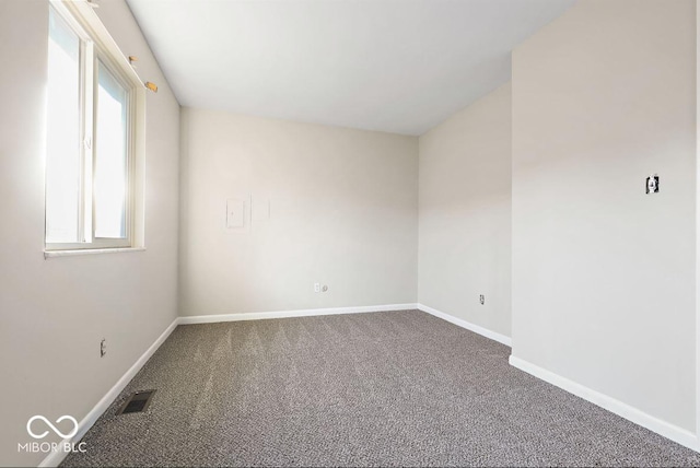 empty room featuring carpet, visible vents, and baseboards