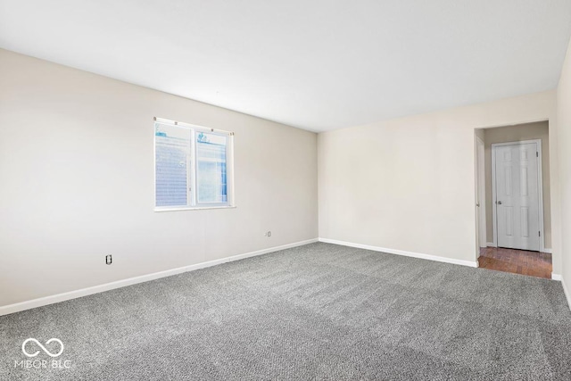 carpeted empty room featuring baseboards