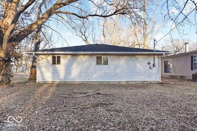 view of property exterior featuring a chimney and central AC