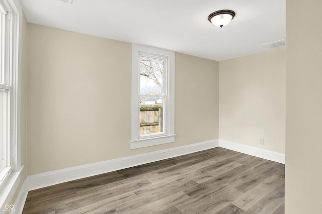 spare room featuring baseboards and wood finished floors