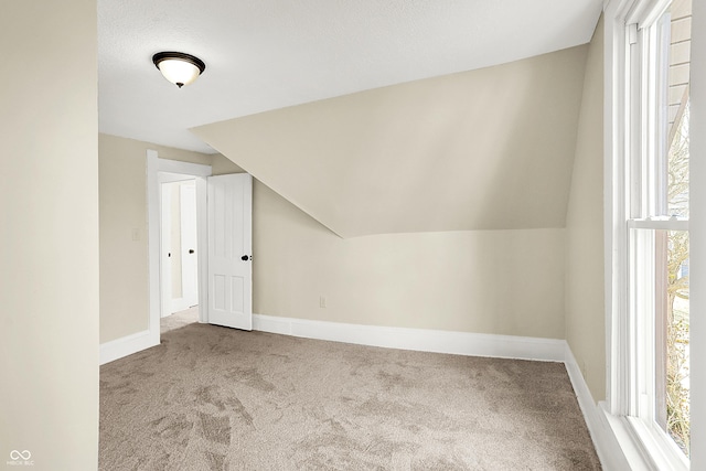 additional living space with lofted ceiling, carpet, and baseboards