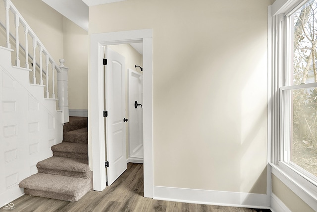 staircase featuring baseboards and wood finished floors