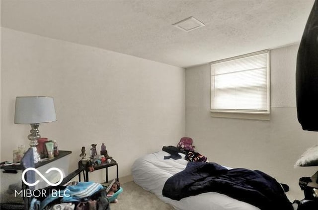 bedroom with carpet floors and a textured ceiling