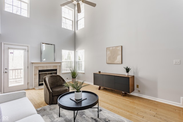 living room featuring a wealth of natural light, a fireplace, baseboards, and hardwood / wood-style floors