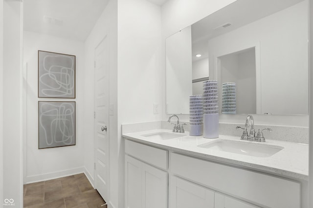 bathroom featuring visible vents, a sink, baseboards, and double vanity