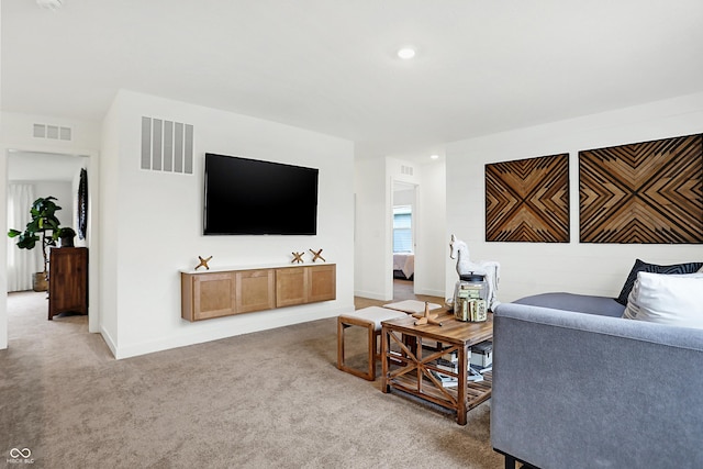 living area featuring light colored carpet, visible vents, baseboards, and recessed lighting