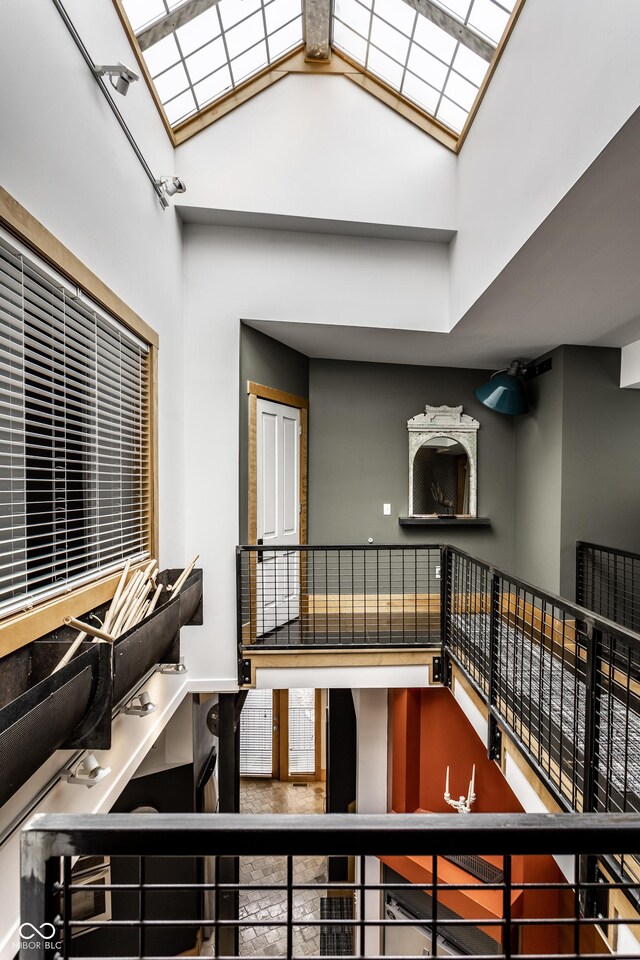 stairs with a skylight and high vaulted ceiling