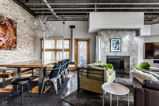 living area featuring a chandelier, a tile fireplace, and a high ceiling