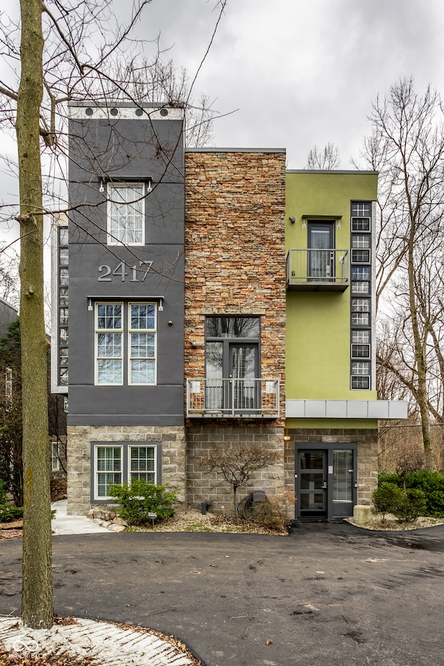 exterior space featuring stucco siding and stone siding