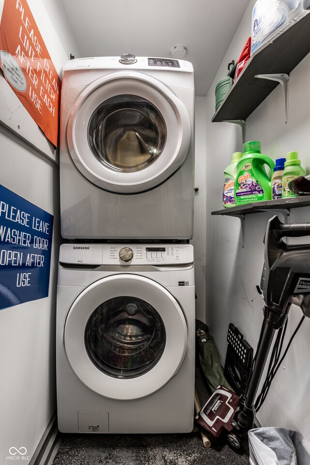 clothes washing area featuring stacked washer and dryer and laundry area