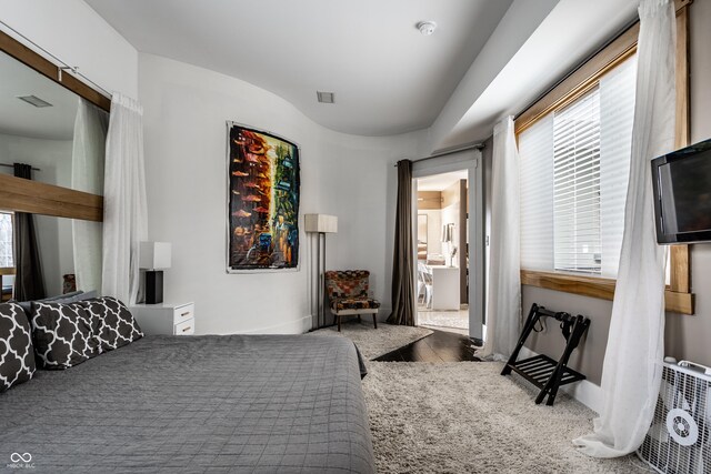 bedroom featuring visible vents and wood finished floors