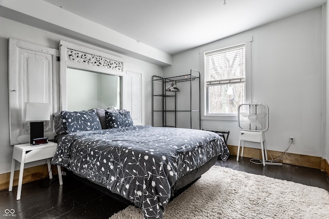 bedroom with baseboards and wood-type flooring