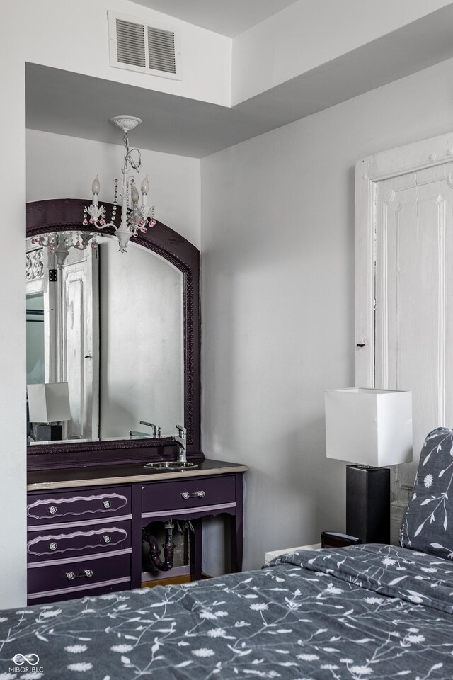 bedroom with visible vents and an inviting chandelier