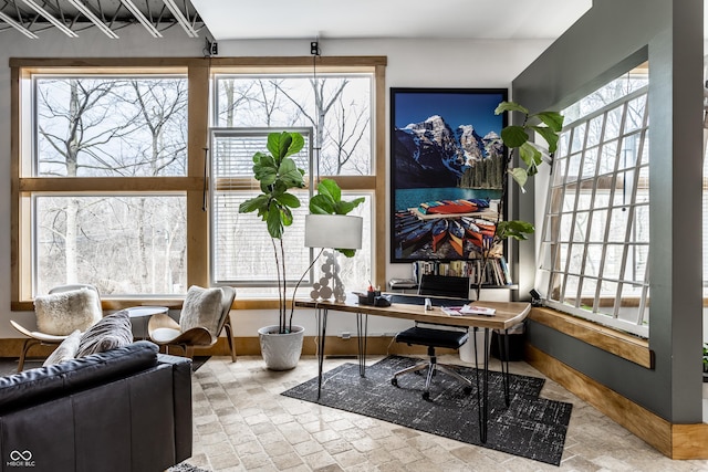 office space with brick floor, plenty of natural light, and baseboards