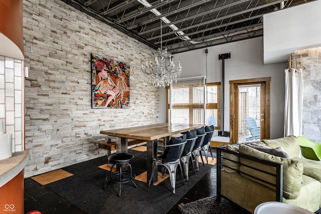dining space featuring a chandelier and a towering ceiling