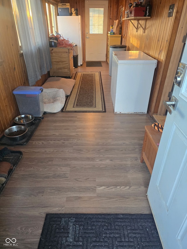 interior space with wood finished floors, washer / dryer, and wooden walls